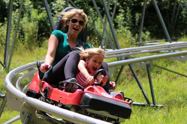 Woman & daughter on Mountain Coaster at Holiday Valley Resort in warm weather