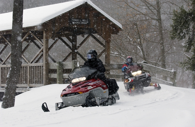 Snowmobiles exiting the Thomas L. Kelly Covered Bridge in Allegany State Park