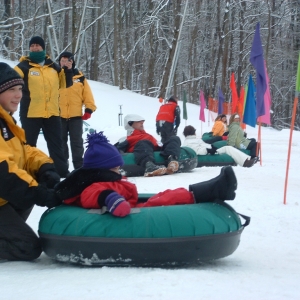 People getting ready to slide down the big hill at Holiday Valley Tubing Company